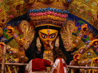 Married women offer their final prayer to Goddess Durga by presenting vermillion and sweets before the immersion of Durga idols on the last...