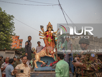 Bangladeshi Hindu devotees immerse an idol of their deity Durga into the Buriganga River during celebrations on the last day of the Durga Pu...