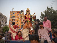 Bangladeshi Hindu devotees immerse an idol of their deity Durga into the Buriganga River during celebrations on the last day of the Durga Pu...