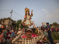 Bangladeshi Hindu devotees immerse an idol of their deity Durga into the Buriganga River during celebrations on the last day of the Durga Pu...