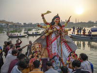 Bangladeshi Hindu devotees immerse an idol of their deity Durga into the Buriganga River during celebrations on the last day of the Durga Pu...