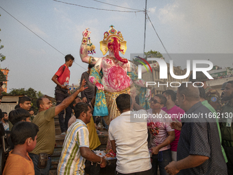 Bangladeshi Hindu devotees immerse an idol of their deity Durga into the Buriganga River during celebrations on the last day of the Durga Pu...