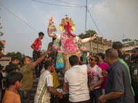 Bangladeshi Hindu devotees immerse an idol of their deity Durga into the Buriganga River during celebrations on the last day of the Durga Pu...