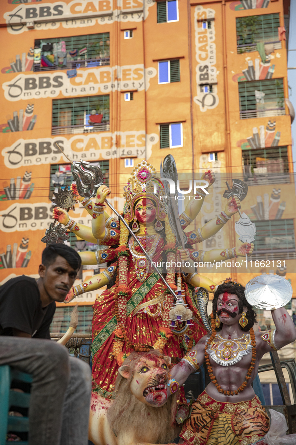 Bangladeshi Hindu devotees gather to immerse an idol of their deity Durga into the Buriganga River during celebrations on the last day of th...