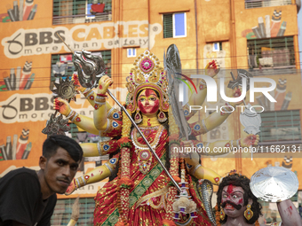 Bangladeshi Hindu devotees gather to immerse an idol of their deity Durga into the Buriganga River during celebrations on the last day of th...