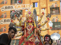 Bangladeshi Hindu devotees gather to immerse an idol of their deity Durga into the Buriganga River during celebrations on the last day of th...