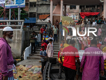 Bangladeshi Hindu devotees immerse an idol of their deity Durga into the Buriganga River during the last day of the Durga Puja, the largest...