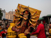 Bangladeshi Hindu devotees immerse an idol of their deity Durga into the Buriganga River during the last day of the Durga Puja, the largest...