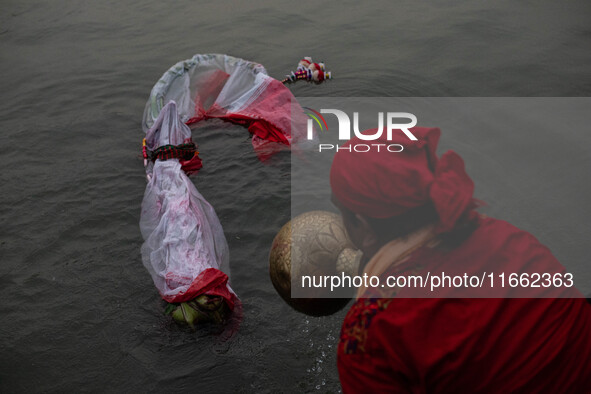 Bangladeshi Hindu devotees immerse an idol of their deity Durga into the Buriganga River during the last day of the Durga Puja, the largest...