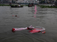 Bangladeshi Hindu devotees immerse an idol of their deity Durga into the Buriganga River during the last day of the Durga Puja, the largest...