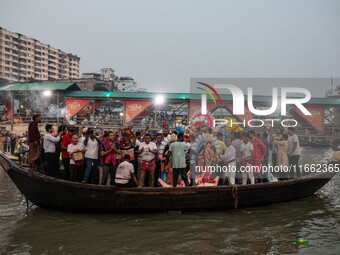 Bangladeshi Hindu devotees immerse an idol of their deity Durga into the Buriganga River during the last day of the Durga Puja, the largest...