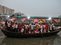 Bangladeshi Hindu devotees immerse an idol of their deity Durga into the Buriganga River during the last day of the Durga Puja, the largest...