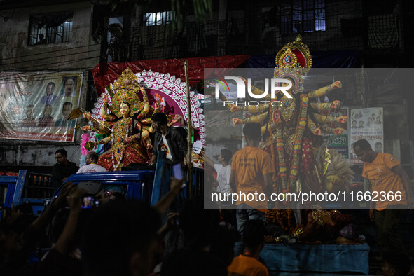 Bangladeshi Hindu devotees immerse an idol of their deity Durga into the Buriganga River during the last day of the Durga Puja, the largest...