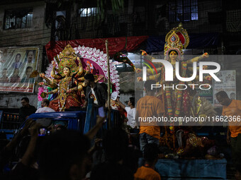 Bangladeshi Hindu devotees immerse an idol of their deity Durga into the Buriganga River during the last day of the Durga Puja, the largest...