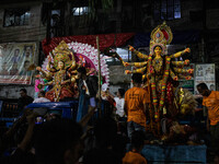 Bangladeshi Hindu devotees immerse an idol of their deity Durga into the Buriganga River during the last day of the Durga Puja, the largest...