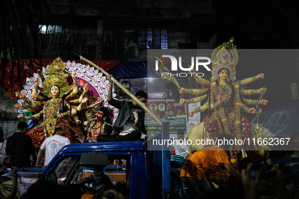 Bangladeshi Hindu devotees immerse an idol of their deity Durga into the Buriganga River during the last day of the Durga Puja, the largest...