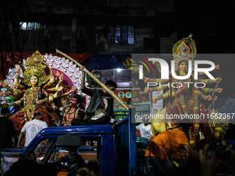 Bangladeshi Hindu devotees immerse an idol of their deity Durga into the Buriganga River during the last day of the Durga Puja, the largest...