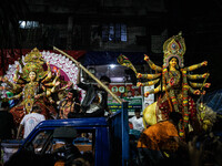 Bangladeshi Hindu devotees immerse an idol of their deity Durga into the Buriganga River during the last day of the Durga Puja, the largest...