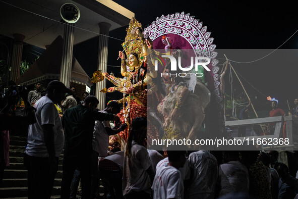 Bangladeshi Hindu devotees immerse an idol of their deity Durga into the Buriganga River during the last day of the Durga Puja, the largest...