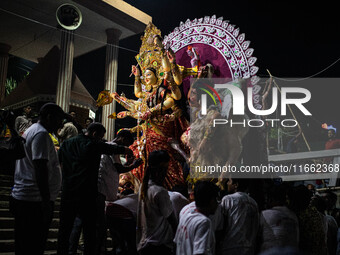 Bangladeshi Hindu devotees immerse an idol of their deity Durga into the Buriganga River during the last day of the Durga Puja, the largest...