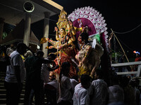 Bangladeshi Hindu devotees immerse an idol of their deity Durga into the Buriganga River during the last day of the Durga Puja, the largest...