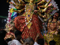 Bangladeshi Hindu devotees immerse an idol of their deity Durga into the Buriganga River during the last day of the Durga Puja, the largest...