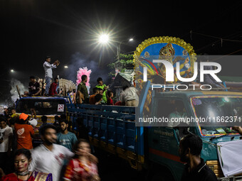 Bangladeshi Hindu devotees immerse an idol of their deity Durga into the Buriganga River during the last day of the Durga Puja, the largest...