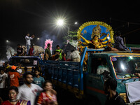 Bangladeshi Hindu devotees immerse an idol of their deity Durga into the Buriganga River during the last day of the Durga Puja, the largest...