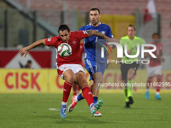 In Ta' Qali, Malta, on October 13, 2024, Kurt Shaw of Malta is closely followed by Artur Ionita of Moldova during the UEFA Nations League, L...