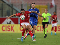 In Ta' Qali, Malta, on October 13, 2024, Kurt Shaw of Malta is closely followed by Artur Ionita of Moldova during the UEFA Nations League, L...