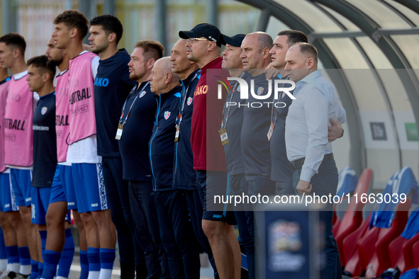 Serghei Cleşcenco (right), head coach of Moldova, coaching staff members, and substitute players stand during the playing of their country’s...