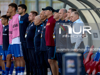 Serghei Cleşcenco (right), head coach of Moldova, coaching staff members, and substitute players stand during the playing of their country’s...