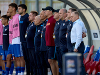 Serghei Cleşcenco (right), head coach of Moldova, coaching staff members, and substitute players stand during the playing of their country’s...