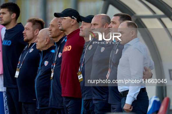 Serghei Cleşcenco (right), head coach of Moldova, and coaching staff members stand during the playing of their country’s national anthem bef...