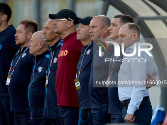 Serghei Cleşcenco (right), head coach of Moldova, and coaching staff members stand during the playing of their country’s national anthem bef...