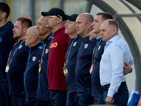 Serghei Cleşcenco (right), head coach of Moldova, and coaching staff members stand during the playing of their country’s national anthem bef...