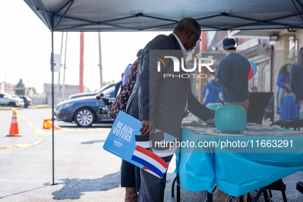 A man picks out Harris-Walz campaign posters at a campaign event in Philadelphia, Pennsylvania, United States, on October 13, 2024. 