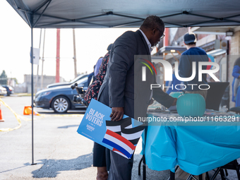 A man picks out Harris-Walz campaign posters at a campaign event in Philadelphia, Pennsylvania, United States, on October 13, 2024. (