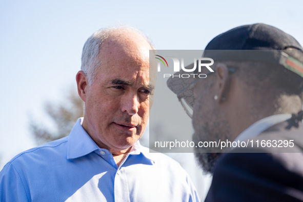 Sen. Bob Casey (D-PA) speaks to a man outside a campaign rally in Philadelphia, Pennsylvania, United States, on October 13, 2024. 