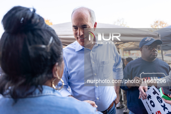 Sen. Bob Casey (D-PA) speaks to a woman outside a campaign rally in Philadelphia, Pennsylvania, United States, on October 13, 2024. 