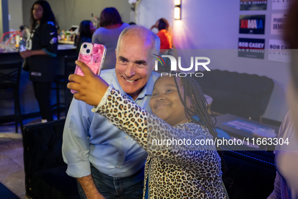 Sen. Bob Casey (D-PA) poses for a selfie with a child at a campaign rally in Philadelphia, Pennsylvania, United States, on October 13, 2024....