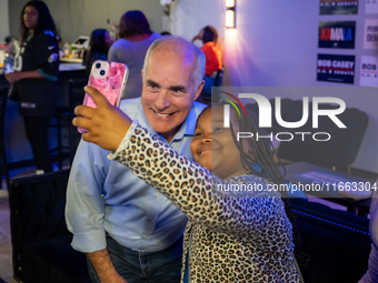 Sen. Bob Casey (D-PA) poses for a selfie with a child at a campaign rally in Philadelphia, Pennsylvania, United States, on October 13, 2024....