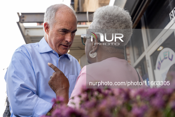 Sen. Bob Casey (D-PA) speaks to a woman outside a campaign rally in Philadelphia, Pennsylvania, United States, on October 13, 2024. 