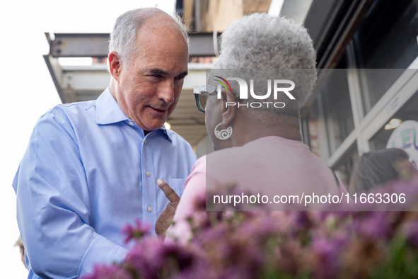 Sen. Bob Casey (D-PA) speaks to a woman outside a campaign rally in Philadelphia, Pennsylvania, United States, on October 13, 2024. 