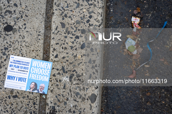 A voter pamphlet lies on the ground outside a campaign event in Philadelphia, Pennsylvania, United States, on October 13, 2024. 