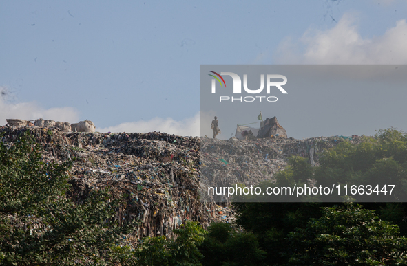 A man walks in a dump site at Olusosun during the summit to discuss ''Mental Health at Work'' in commemoration of 2024 World Mental Health D...