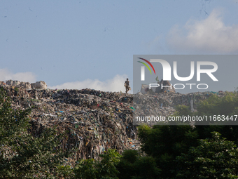 A man walks in a dump site at Olusosun during the summit to discuss ''Mental Health at Work'' in commemoration of 2024 World Mental Health D...