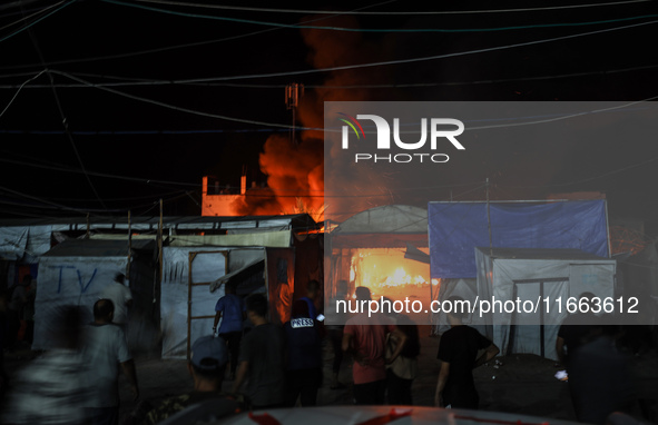 Rescuers work at the site of an Israeli strike on tents sheltering displaced people amid the Israel-Hamas conflict in Deir Al-Balah, Gaza St...