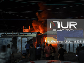 Rescuers work at the site of an Israeli strike on tents sheltering displaced people amid the Israel-Hamas conflict in Deir Al-Balah, Gaza St...