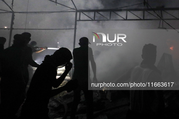 Rescuers work at the site of an Israeli strike on tents sheltering displaced people amid the Israel-Hamas conflict in Deir Al-Balah, Gaza St...